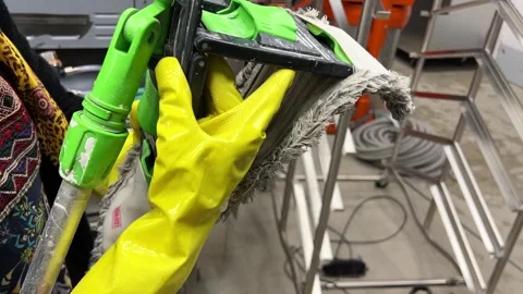 Put a wet cloth on a plastic mop with yellow gloved hands Video stock 264510659