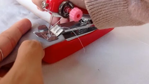 Put a white thread into a tiny sewing tool Stock Footage 145623865