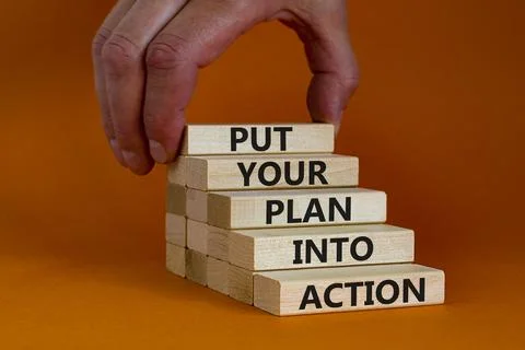 Put your plan into action symbol. Wooden blocks with words Put your plan into Stock Photos