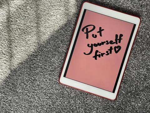 Put yourself first hand written note on digital tablet Stock-Fotos