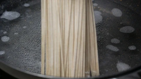 Put Zaru Soba (Cold Soba Japanese Noodles food style) into boiled hot water a Stock Footage 89762413