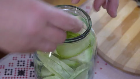 Put the zucchini in the jar with your hands Video stock 280164256