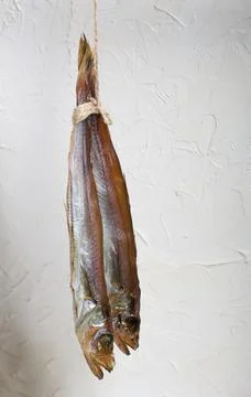 Putassu Cold smoked. Hanging on a string. The fish is wrapped with a strip .. Stock Photos