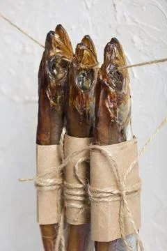 Putassu Cold smoked. Hanging on a string. The fish is wrapped with a strip .. Stock Photos