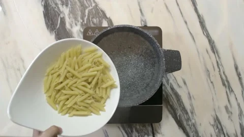 Puting pasta in boiling water, top view Stock Footage 135478142