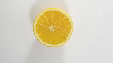Puts a half ripe orange on the table. view from above Stock Footage 124084063