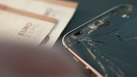 Puts the Money next to the Broken Phone. Stock Footage 263076466