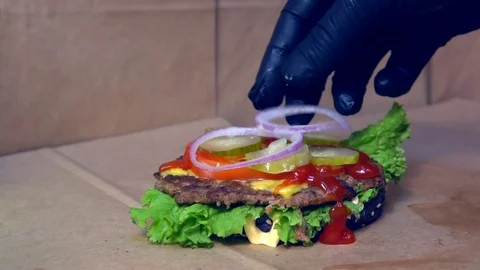Puts onions on a hamburger Vídeo Stock 84817286