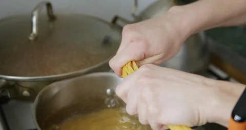 Puts pasta spaghetti in a pot of boiling water Stock Footage 105126620