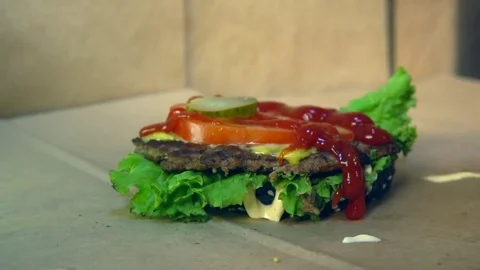 Puts pickles on a Burger Vídeo Stock 84817292