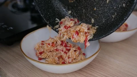 Puts rice with vegetables and chicken on a plate Stock Footage 305306592