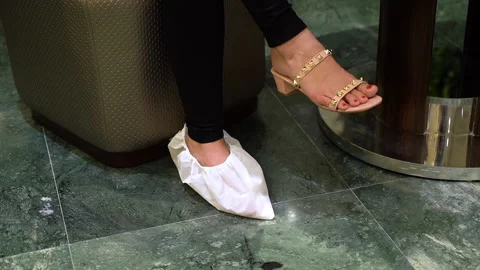Puts on shoe covers Stock-Footage 135516757