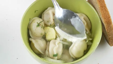 Puts the sour cream in the dumplings.Eating lunch vareniki with meat. Stock-Footage 136285523