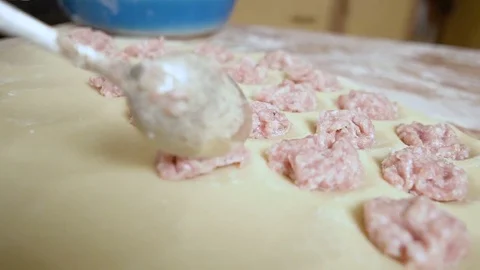 Puts the stuffing on the dough carefully with a spoon hd Video stock 80044302
