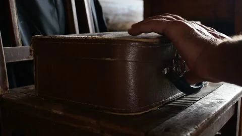 Puts suitcase on a chair and opens it, vintage Stock Footage 135412756