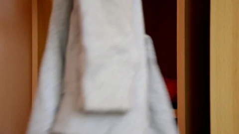 Puts things clothes in a closet on a shelf, multi-colored t-shirts, wardrobe Stock Footage 125229890