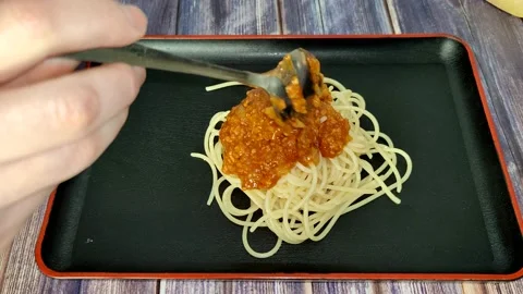 Puts a tomato bolognese on boiled spaghetti Stock Footage 227722884