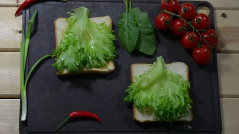 Puts two sheets of fresh salad on the toast. healthy breakfast Stock Footage 122490185