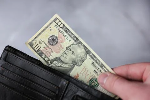 Puts in wallet or pulls out 10 dollar bill Stock Photos