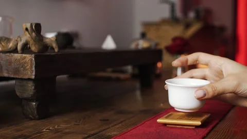 Puts a white mug of tea on the table Stock Footage 139331509