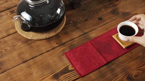 Puts a white mug of tea on the table Stock Footage 139331528