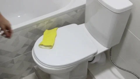 Puts On The Yellow Gloves For Start Cleaning The Toilet Stock Footage 127981578