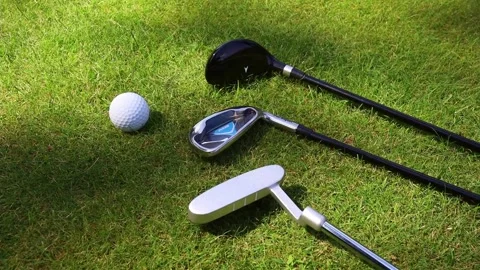 Putters and ball on a green golf course Stockbeeldmateriaal 166593505