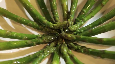 Putting aspargus on a plate Stockbeeldmateriaal 75276399