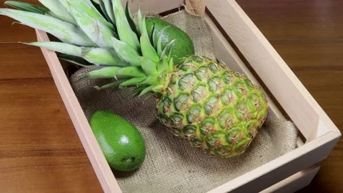 Putting avocado in the pineapple and avocado crate 스톡 동영상 184608559