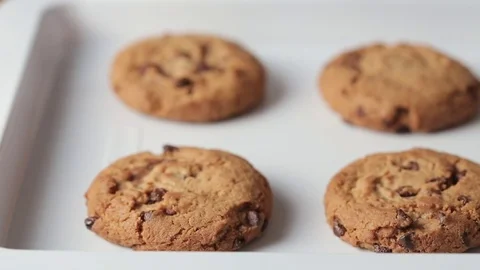 Putting baking tray with chocolate chip cookies on the wooden table. Stock Footage