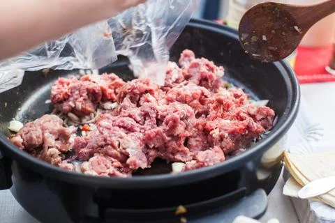 Putting beef meat in the pan Stock Photos
