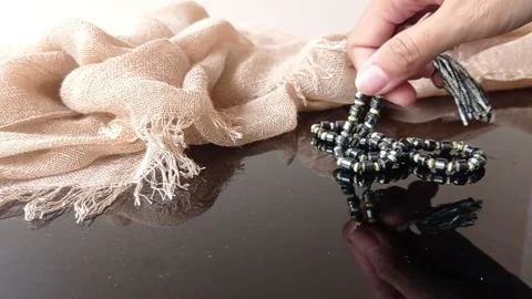 Putting a black prayer bead on a black table Stock Footage 146258394
