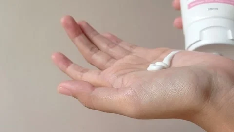 Putting in a body lotion into a hand for moisturing the skin Stock Footage 151025816