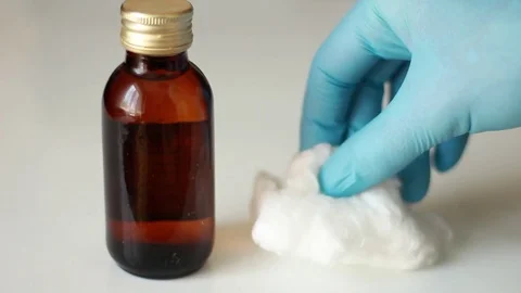 Putting a bottle of alcohol with cotton Vídeos de archivo 76996080