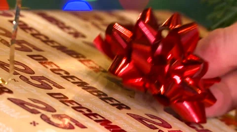 Putting bow on a christmas present under christmas tree HD Stock Footage 56236735
