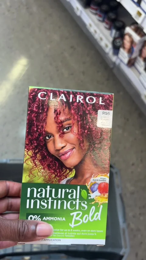 Putting a box of Clairol Bold Natural Instincts in a shopping basket Stock Footage 334580608