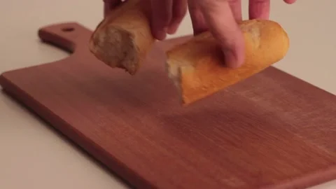 Putting a bread in a wood board Stock Footage 133816083