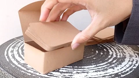 Putting the brown papers into the small cardboard Stock Footage 145567249
