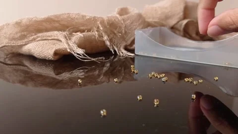 Putting brown pearls into a box Stock Footage 146257380