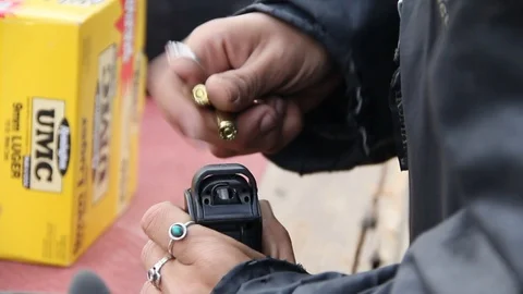 Putting bullets in gun Stock Footage 113911313