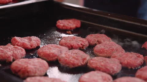 Putting burger patties on the grill Stock Footage 337688439