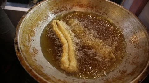 Putting cakwe into a boiling frying pan Video stock 270347238