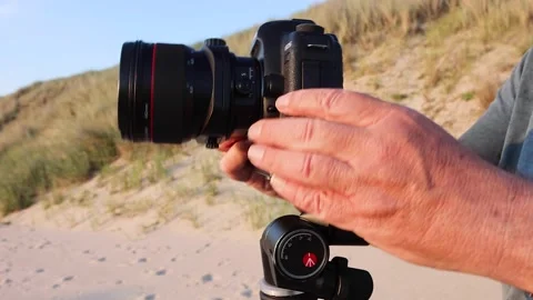 Putting camera on tripod at the beach Stock Footage 218264947