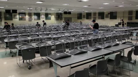 Putting up chairs in cafeteria Stock Footage