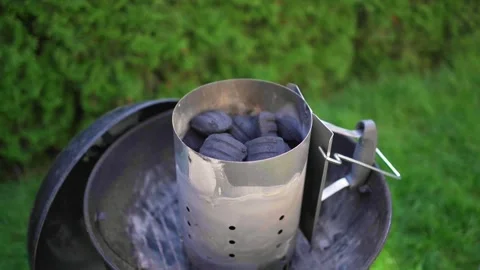 Putting Charcoal into starter of grill Stock Footage 246661326