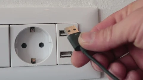 Putting the charger cable in the wall usb Stock Footage 107389536