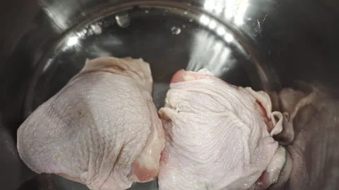 Putting chicken thighs into a silver pot Stock Footage 328649044
