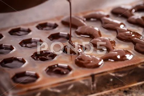 Putting chocolate in mold Stock Photos