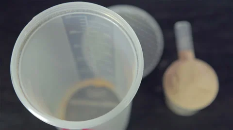 Putting  chocolate whey isolate protein into plastic white shaker Stock Footage 35587008