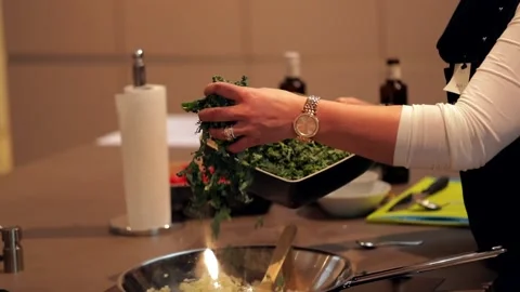 Putting chopped kale in a pan in slow motion Stock Footage 149118701
